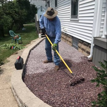 Maya-Bruns Landscaping - a man using a rake to trim a flower bed - Landscaping Near Me - Beloit, Wisconsin Maya-Bruns Landscaping - a man using a rake to trim a flower bed - Landscaping Near Me - Beloit, Wisconsin