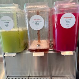 three juice dispensers with labels on them three juice dispensers with labels on them
