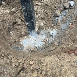 FenceItForU - They dumped a small cup of cement powder on top - no water added and then took stones from neighbors yard and jammed into the ground