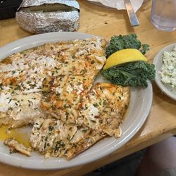 Flounder filet with baked potato and coleslaw.