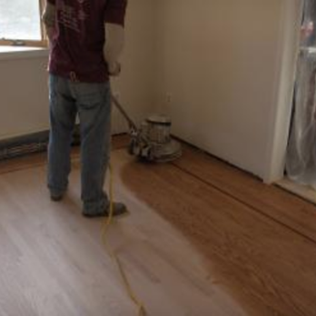Embleton Flooring - a man using a mop to clean a hardwood floor - Flooring Near Me