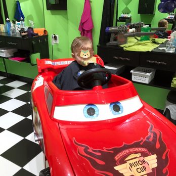 Sharkey's Cuts for Kids - Sitting in the race car before the trim. - Kids Hair Salons Near Me - Cary, North Carolina Sharkey's Cuts for Kids - Sitting in the race car before the trim. - Kids Hair Salons Near Me - Cary, North Carolina