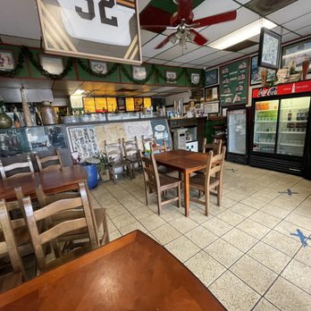 Paul's Deli - Dining area, including a half-full beverage refrigerator and stuff stored in the corner. - Delis Near Me - Westminster, California