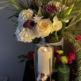 a vase of flowers and a candle a vase of flowers and a candle