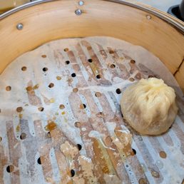 Soup dumpling. One spilled with trying to get it out... Can see lots of soup inside Soup dumpling. One spilled with trying to get it out... Can see lots of soup inside