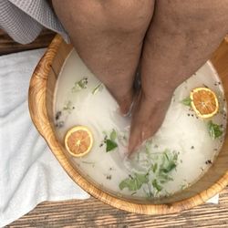 Den Mother Wellness - Feet soaking in the garden of herbs