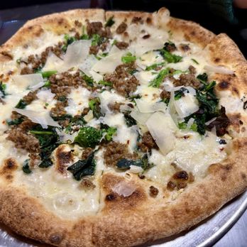Calogero's - Salsiccia e rapini - A pizza with sausage, greens, and cheese, baked with a golden crust, served on a metal tray. - Pizza Near Me - Naperville , Illinois