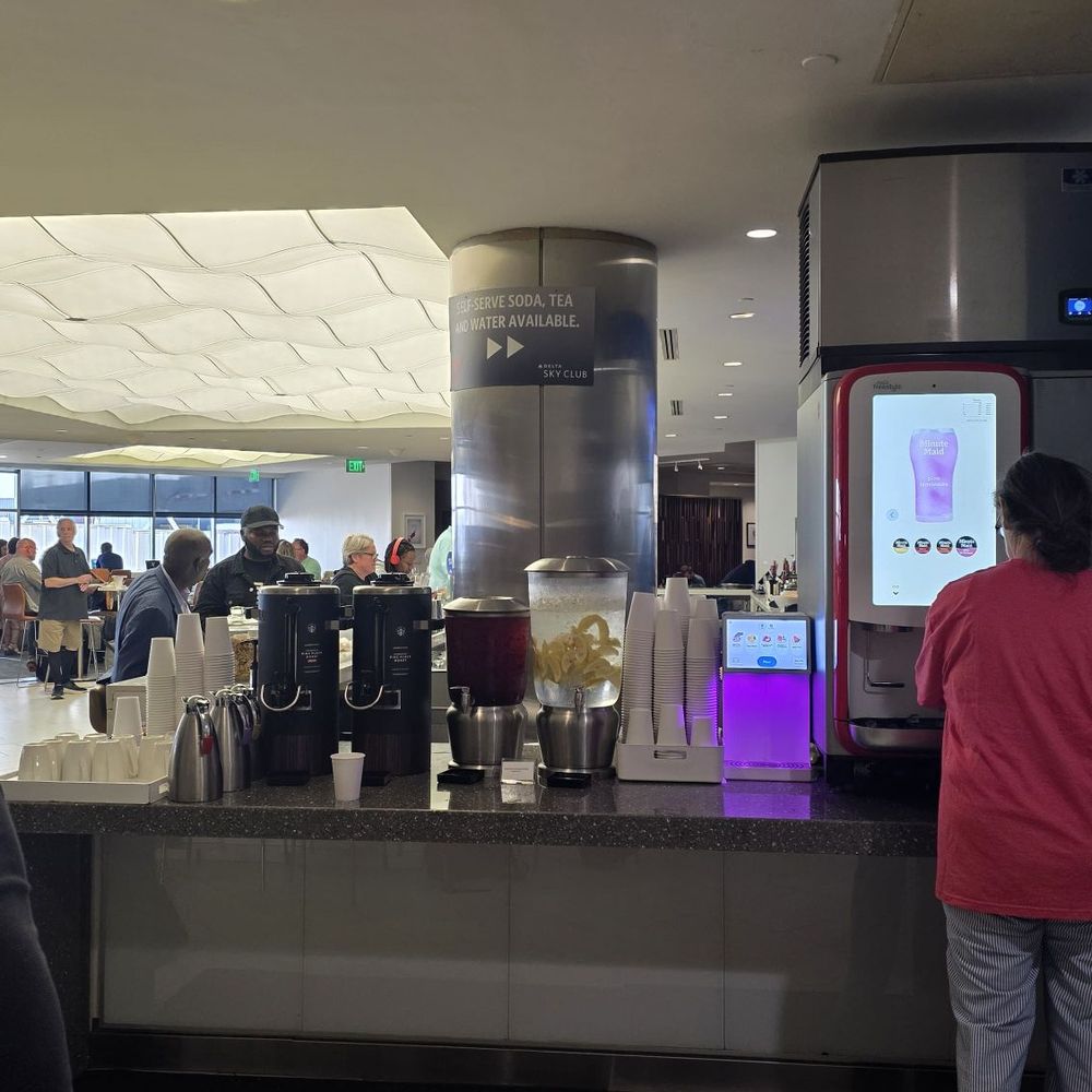 Delta Sky Club - Concourse E - Self serve drink station and the bar beyond - Airport Lounges Near Me - Atlanta, Georgia Delta Sky Club - Concourse E - Self serve drink station and the bar beyond - Airport Lounges Near Me - Atlanta, Georgia