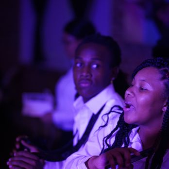 Jazz Poetry Cafe - a woman in a white shirt and tie singing into a microphone - Music Venues Near Me - Jacksonville, Florida Jazz Poetry Cafe - a woman in a white shirt and tie singing into a microphone - Music Venues Near Me - Jacksonville, Florida
