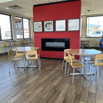Wendy's - a woman sitting at a table in front of a fireplace - Burgers Near Me - Beaver, Utah