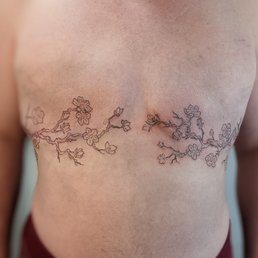 Mastectomy scar coverup tattoo: linework of a cherry blossom branch extending from under each arm, nearly meeting in the middle. Mastectomy scar coverup tattoo: linework of a cherry blossom branch extending from under each arm, nearly meeting in the middle.