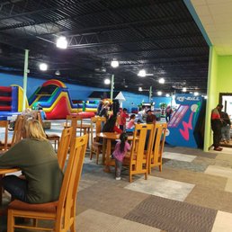Children enjoying bounce houses and arcade games . Children enjoying bounce houses and arcade games .