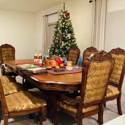 a dining room table with a christmas tree in the background a dining room table with a christmas tree in the background