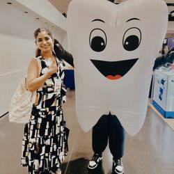 Live & Smile Dental & Orthodontics - Dr. Naina posing next to tooth cosplay at Bay Area Dental Expo 2026 at Santa Clara Convention Center.