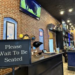 a sign that reads please wait to be seated a sign that reads please wait to be seated