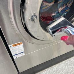 A broken washing machine with a gentleman's laundry inside. A broken washing machine with a gentleman's laundry inside.
