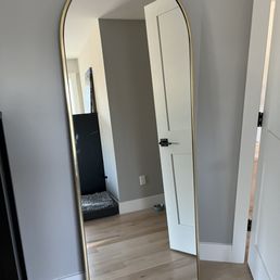 Secured floor length mirror to wall