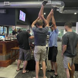 People doing kegstands inside the bar People doing kegstands inside the bar