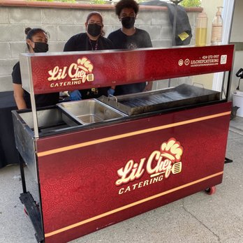 Lil Chef Catering - two men standing behind a food cart - Caterers Near Me Lil Chef Catering - two men standing behind a food cart - Caterers Near Me