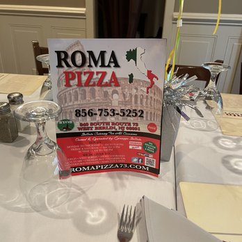 Roma Pizza - a table setting with a menu and a fork and knife - Pizza Near Me - West Berlin, New Jersey Roma Pizza - a table setting with a menu and a fork and knife - Pizza Near Me - West Berlin, New Jersey