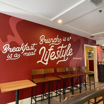 Ruby Sunshine Charleston Downtown - a restaurant with a red wall and wooden tables - Breakfast & Brunch Near Me - Charleston, South Carolina Ruby Sunshine Charleston Downtown - a restaurant with a red wall and wooden tables - Breakfast & Brunch Near Me - Charleston, South Carolina