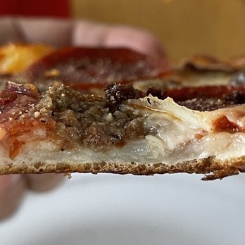 Yaghi's New York Pizzeria - a hand holding a piece of pizza - Pizza Near Me - Pflugerville, Texas Yaghi's New York Pizzeria - a hand holding a piece of pizza - Pizza Near Me - Pflugerville, Texas