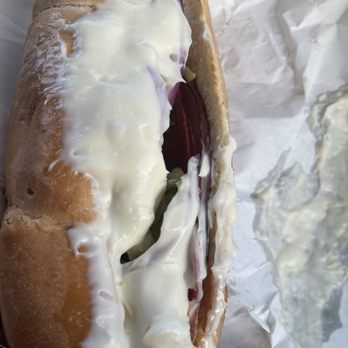 Subway - a hand holding a hot dog covered in cheese and onions - Sandwiches Near Me - Belton, Missouri