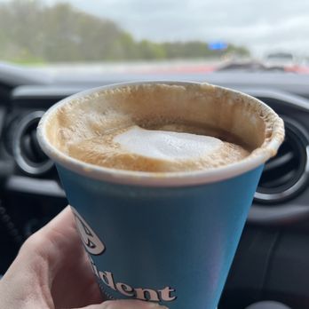 Confident Coffee Roasters - a hand holding a cup of coffee - Coffee & Tea Near Me - Fayetteville, Arkansas