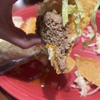 Los Amigos - a hand holding a tortilla sandwich - Mexican Near Me - Seneca, South Carolina