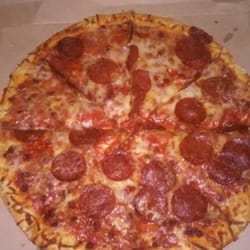 7-Eleven - 5.55 whole pizza, can't beat it for the price.