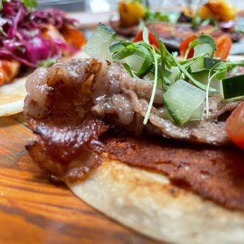 Taft Díaz - a plate of food on a wooden table - New American Near Me - El Paso, Texas Taft Díaz - a plate of food on a wooden table - New American Near Me - El Paso, Texas