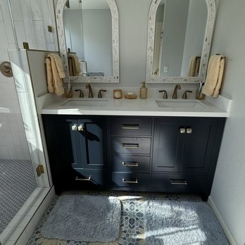 Tony Hernandez Building & Construction - Arielbath vanity in midnight blue with new pulls and decorative knobs, arched mother of pearl mirrors, vanity lights from Lighting New York - General Contractors Near Me