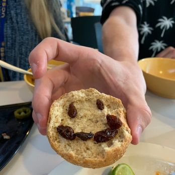 De La Guerra Dining Commons - a person holding a piece of bread with a smiley face drawn on it - Cafes Near Me - Santa Barbara, California
