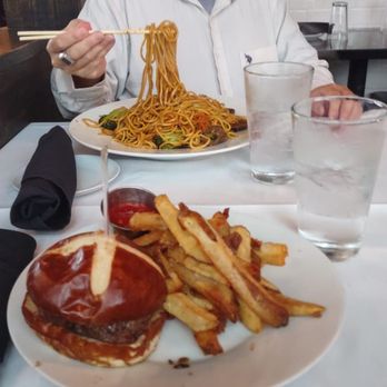 Ditmas Kitchen Boca - a man eating spaghetti with a fork - New American Near Me - Boca Raton, Florida