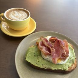 Cornbread Americano and avocado toast topped with bacon and a fried egg.