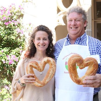 Old School Bakery - a man and woman holding pretzels - Bakeries Near Me - Delray Beach, Florida Old School Bakery - a man and woman holding pretzels - Bakeries Near Me - Delray Beach, Florida