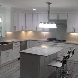 Atlantic Stone Works - White Shaker Cabinets, Super White Quartzite Counter Top, Apron Front SS Sink, Porcelain Tiles, and SS Hardware. Project Complete on 12/2015