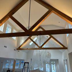 Cape Cod Electrical - Custom-designed beam lighting in a Brewster home--warm LED tape lighting highlights exposed wood trusses for a dramatic, modern look.