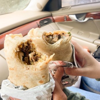 Los Tacos - a person holding a burrito in a car - Mexican Near Me - Temecula, California Los Tacos - a person holding a burrito in a car - Mexican Near Me - Temecula, California