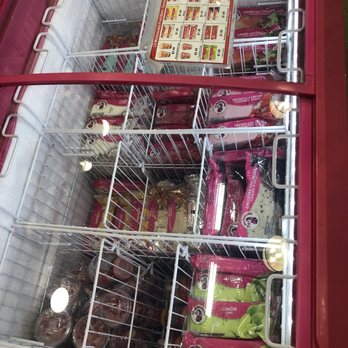 Shell - the inside of a refrigerator filled with food - A freezer with a glass top contains assorted ice cream products, including popsicles and ice cream bars, with a menu card on top. - Gas Stations Near Me - Buckeye, Arizona