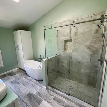 Hom Design and Build - Elegant bathroom with a glass walk-in shower, freestanding tub, tall storage cabinet, double vanity, and green accent walls. - General Contractors Near Me - Fairfax, Virginia