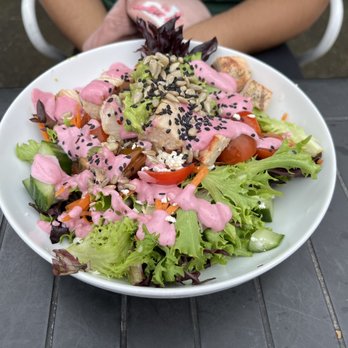 Poa Cafe - a plate of salad with dressing - Juice Bars & Smoothies Near Me - Portland, Oregon