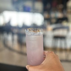 Bar Helios - Lavender lemonade mocktail accented with dehydrated orange slice and piece of lavender