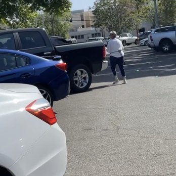 Gather Downtown - Employee putting a note on peoples windshield. - Shopping Centers Near Me - Redding, California