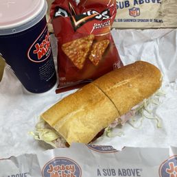 Two sandwiches, nacho cheese Doritos, and pink lemonade.