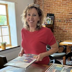 Alan Claude Gallery - Erin is assembling the 2026 Poster Calendar in the Art Gallery