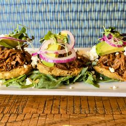 Main & Market - Fried green tomato start topped with house made pulled pork, red onion, feta cheese.