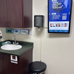 Medallus Medical - In side of a medical room. Chair and a sink as well as monitor that provides information about healthcare.