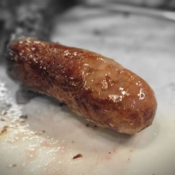 Rodizio Grill - Mesa - Sausage - A sausage with a browned, glazed surface lies on a surface, likely cooked and ready to serve, in a restaurant setting. - Steakhouses Near Me - Mesa, Arizona