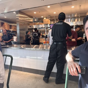 Shake Shack - a man sitting at a table in front of a counter - Fast Food Near Me - Los Angeles, California Shake Shack - a man sitting at a table in front of a counter - Fast Food Near Me - Los Angeles, California